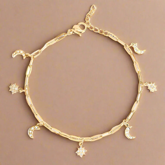 Gold Paper Clip Bracelet with scattered moon and star charms. 