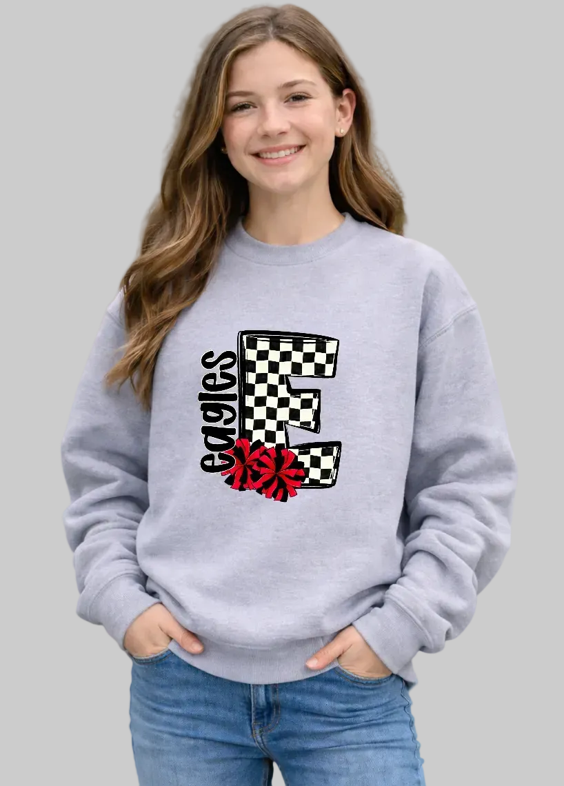 Girl wearing a gray sweatshirt with a checkered letter 'E' and floral design outdoors.