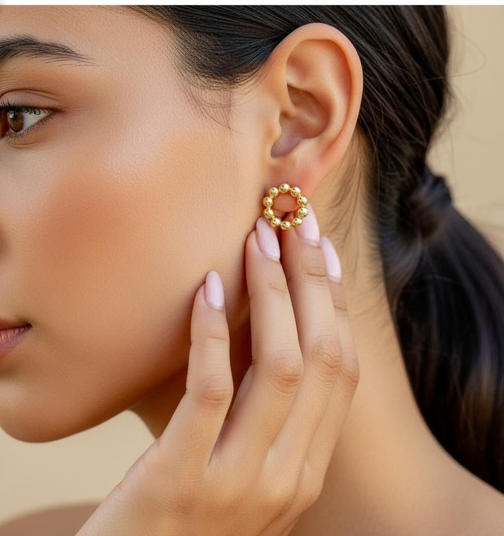 close up of a woman wearing a gold circle stud earring