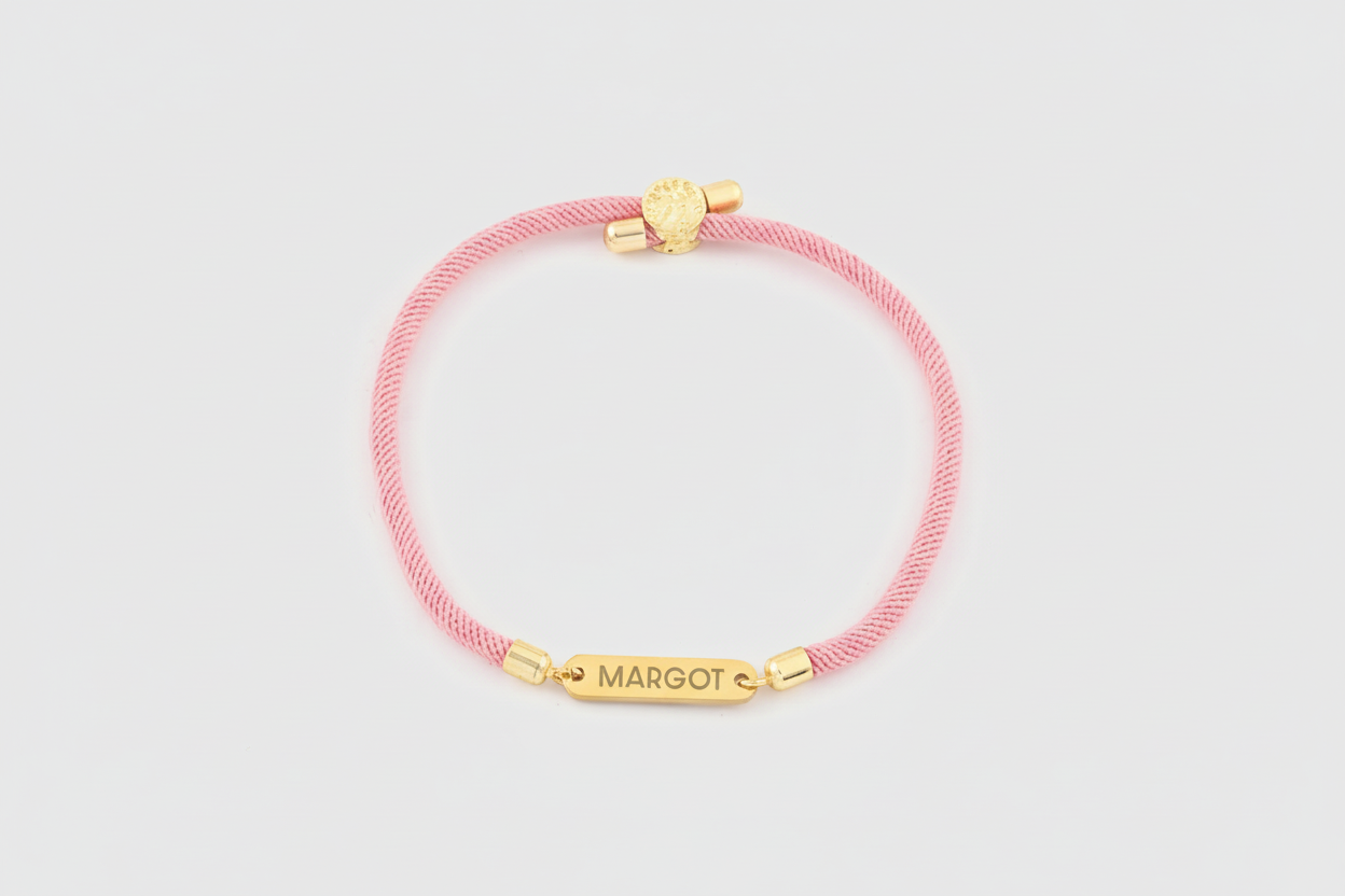 Pink bracelet with gold accents on a light gray background