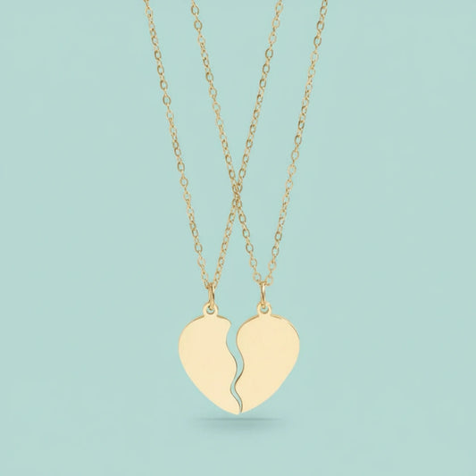 Broken heart shaped pendant necklaces on a light blue background